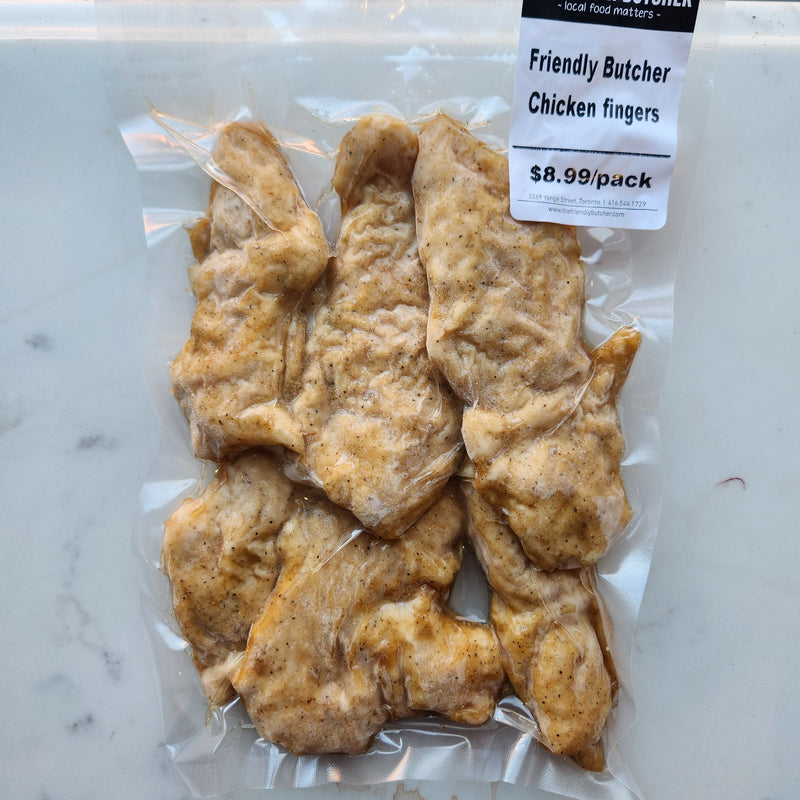Packaged chicken fingers with a label on a marble surface