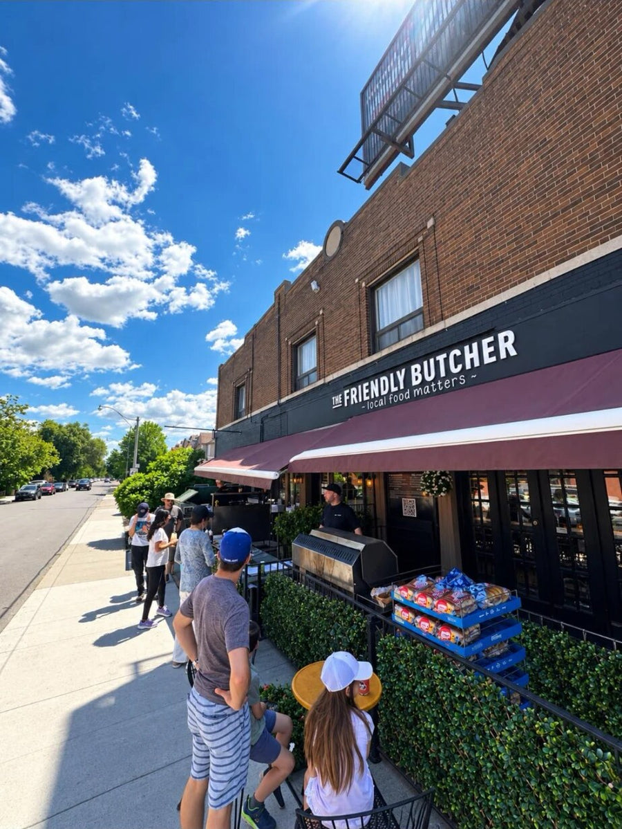 Friendly Butcher staff grilling outside the Yonge Street shop with customers lined up on the patio